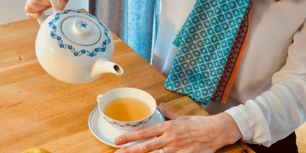 Hand_Teekanne Frau gießt Tee ein